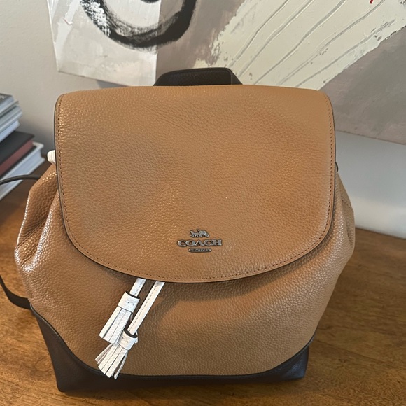 coach backpack white and brown Signature coated canvas Inside zip cell phone and multifunction pockets Laptop compartment with zip closure Zip closure recycled polyester lining Top handle with 2 drop Outside zip pockets Adjustable shoulder straps Fits a 12 (zip compartment) or 13 (main compartment) laptop 10 3/4 (L) x 14 (H) x 5 1/4 (W) Style No. Coach 1941 Brown & White